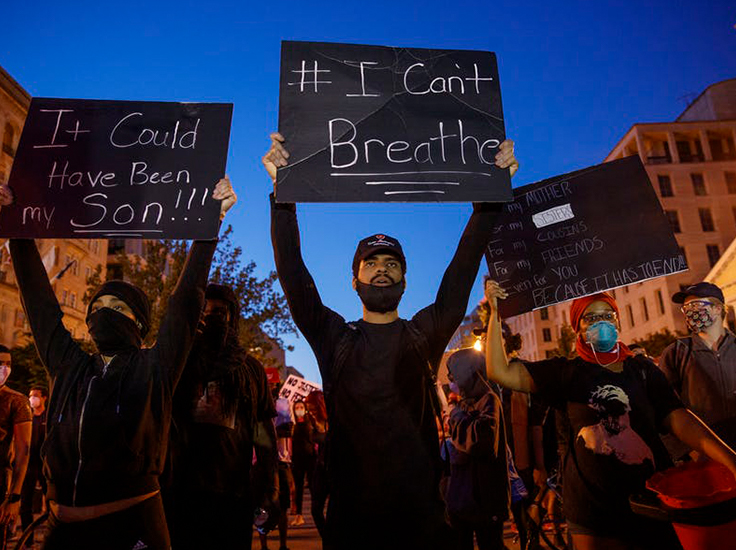 Protesters with signs. Shawn Thew/EPA